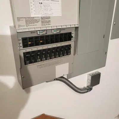 Generator transfer switch installed beside a home electrical panel