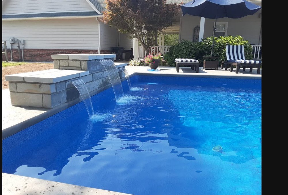 Clear backyard pool with stone waterfall
