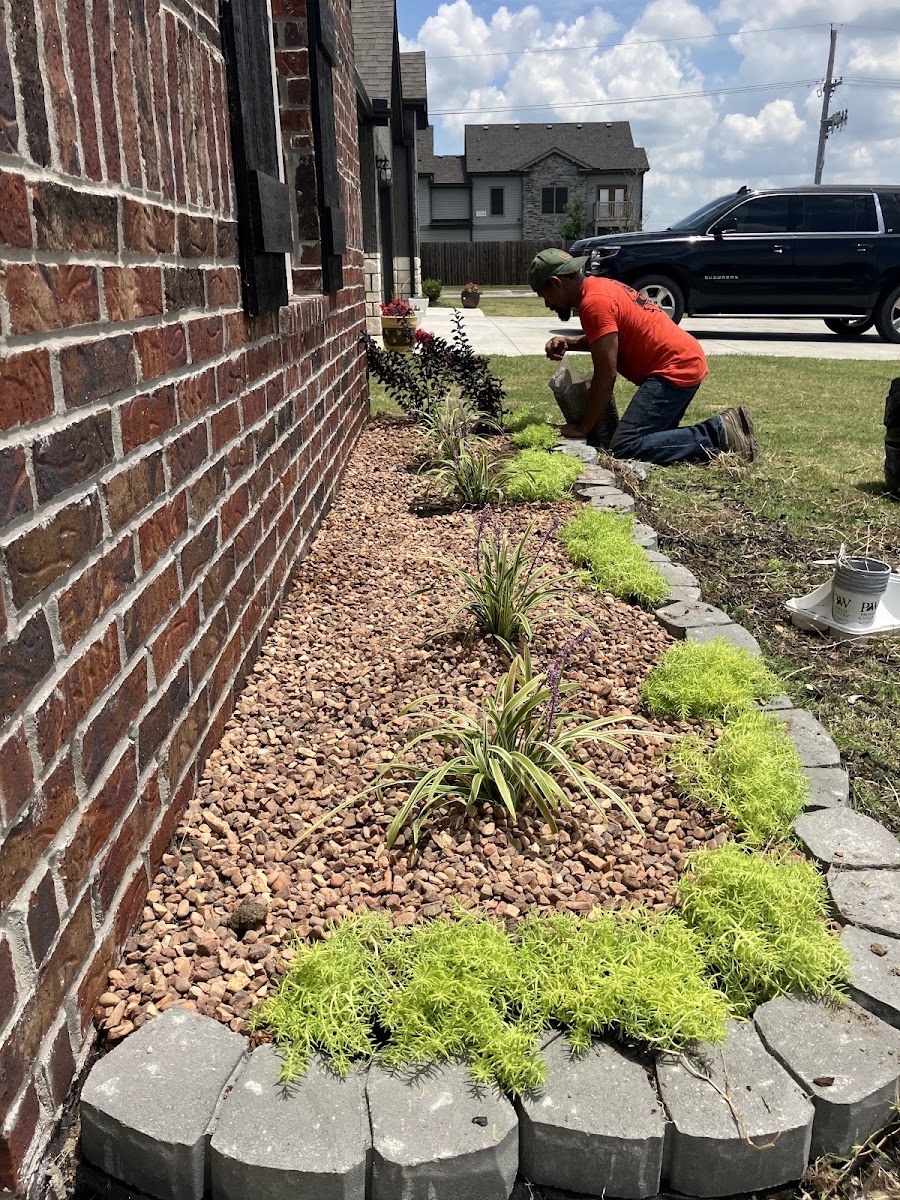Crew installing a landscaped bed along a Bartlesville home