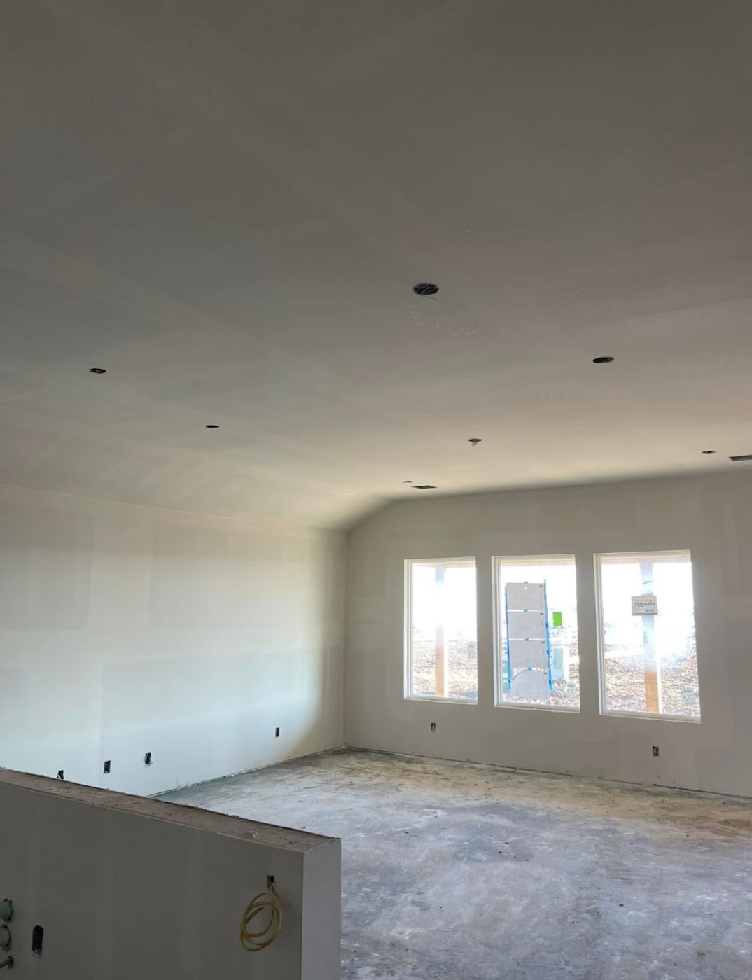 Paint-ready drywall in a bright room